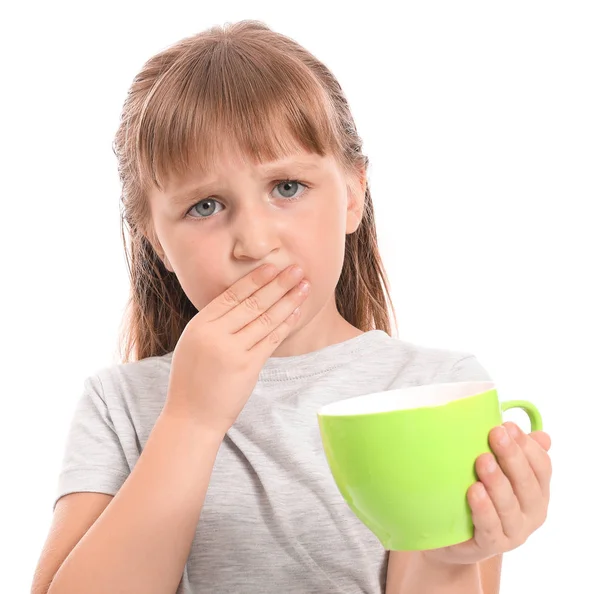 Little girl with sensitive teeth and cup of tea on white background — Stock Photo, Image