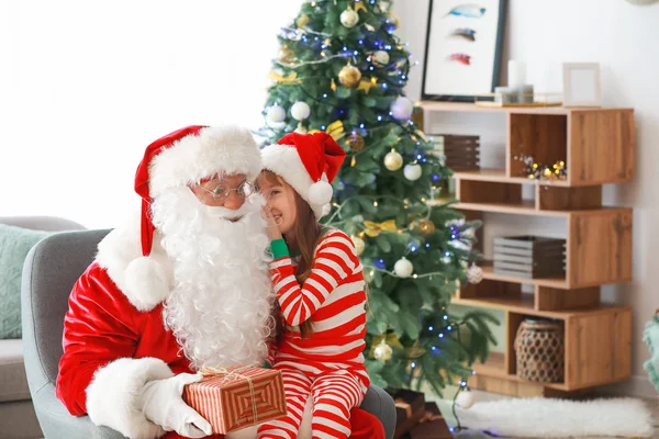 Little girl telling Santa her wish in room decorated for Christmas — Stock Photo, Image