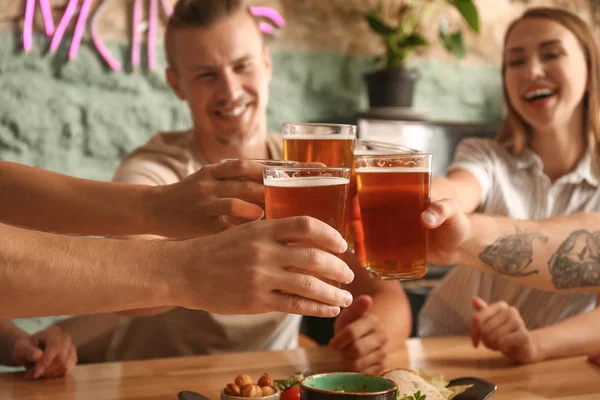 Vänner dricker färskt öl i pub — Stockfoto