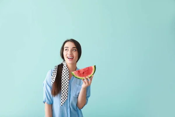 美丽的年轻女子与片新鲜西瓜的颜色背景 — 图库照片
