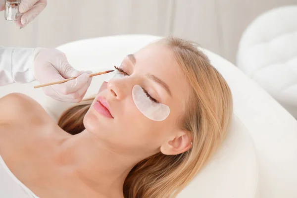 Junge Frau unterzieht sich einer Wimpernfärbung im Schönheitssalon — Stockfoto