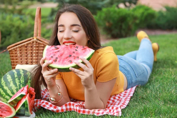 Beautiful young woman eating sweet watermelon in park — Stock Photo, Image