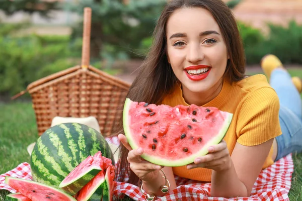 Beautiful young woman eating sweet watermelon in park — Stock Photo, Image