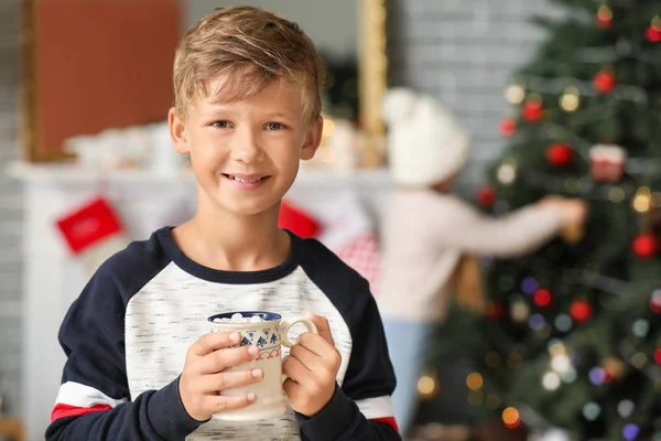 Petit garçon mignon buvant du chocolat chaud à la maison la veille de Noël — Photo