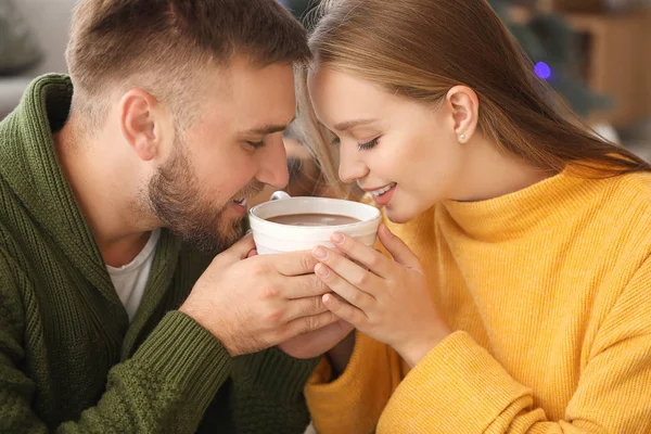 Pareja joven bebiendo chocolate caliente en casa — Foto de Stock