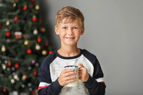 Söt liten pojke dricker varm choklad hemma på julafton — Stockfoto