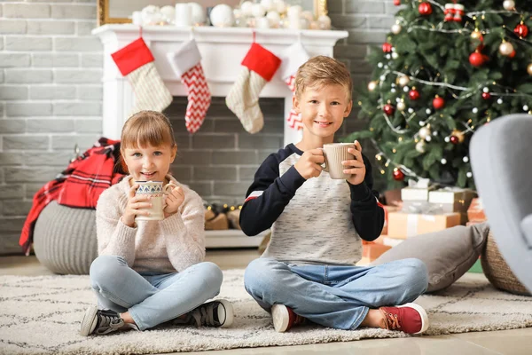 Söta små barn dricker varm choklad hemma på julafton — Stockfoto