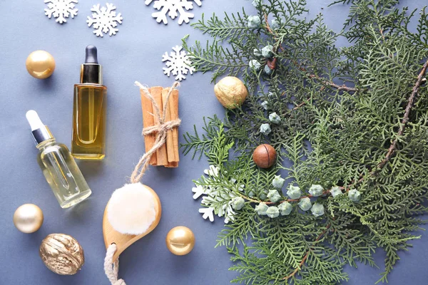 Christmas composition with essential oil for spa treatment on grey background — Stock Photo, Image