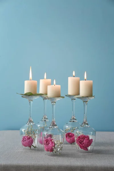 Glasses with flowers and burning candles on table — Stock Photo, Image