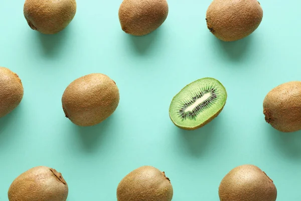 Whole kiwifruits and one half on color background. Concept of uniqueness — Stock Photo, Image