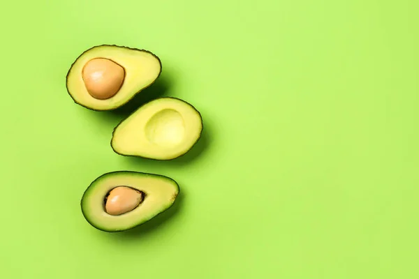 Helften van rijpe avocado op kleur achtergrond — Stockfoto