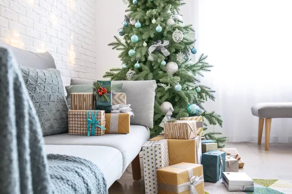 Intérieur de la chambre avec sapin de Noël, canapé et de nombreux cadeaux — Photo