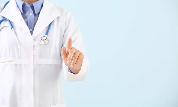 Doctor using virtual screen on color background — Stock Photo, Image