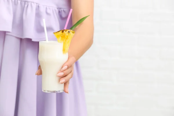 Mulher com copo de saboroso coquetel Pina Colada no fundo branco — Fotografia de Stock