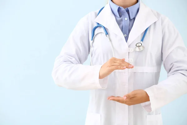 Doctor holding something on color background — Stock Photo, Image