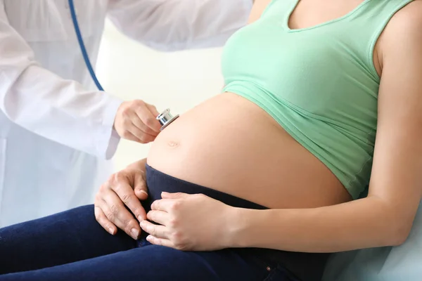 Läkare undersöker gravid kvinna på kliniken — Stockfoto