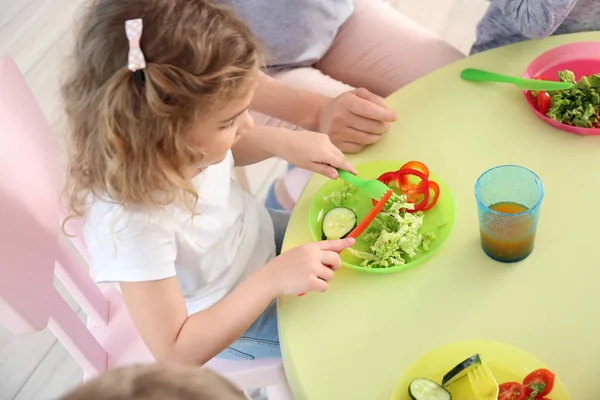 Милые маленькие дети едят вкусный обед в детском саду — стоковое фото