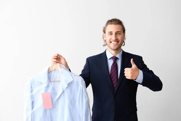 Businessman with clothes after dry-cleaning showing thumb-up on white background — Stock Photo, Image