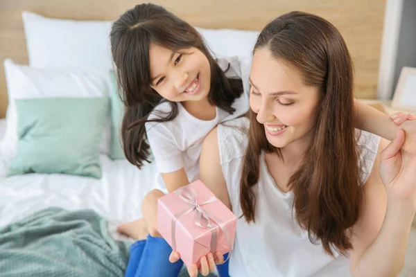 Liten flicka hälsning hennes mamma i sovrummet — Stockfoto