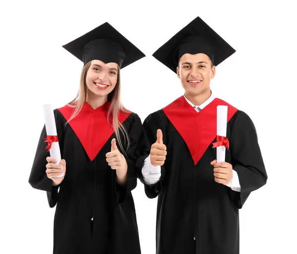 Mladí studenti ve bakalářských róbách a diplomy na bílém pozadí — Stock fotografie