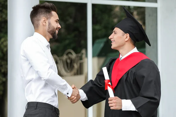 Professor greeting young student on his graduation day — Stock Photo, Image