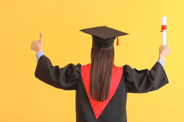 色の背景に卒業証書を持つ女性の卒業生 — ストック写真
