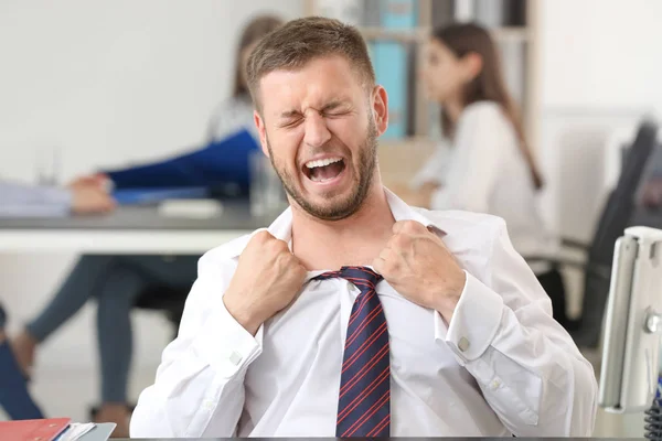 Businessman having panic attack in office