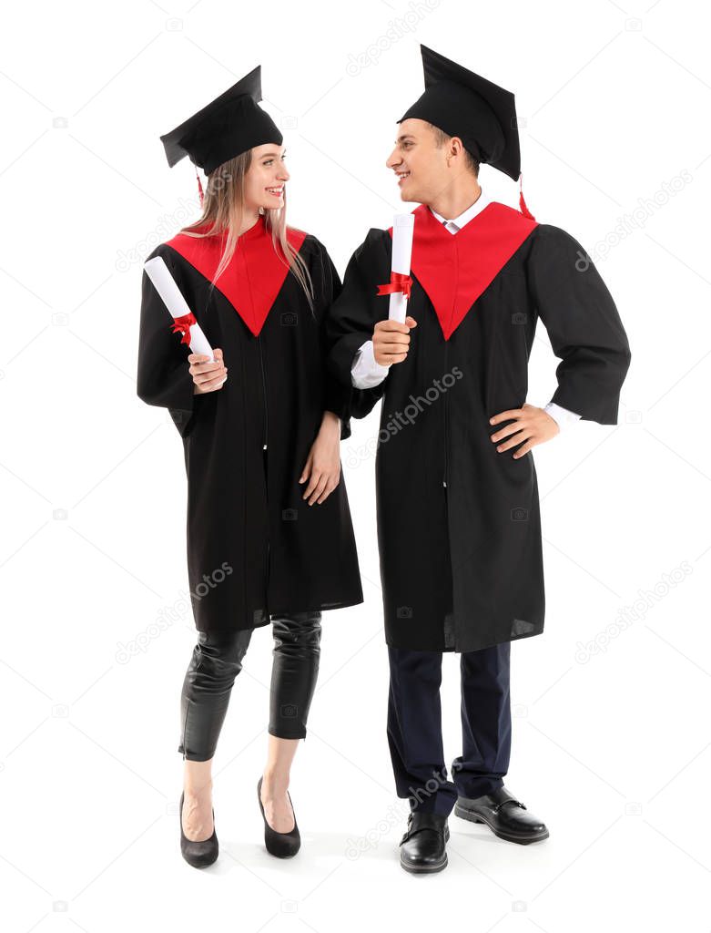 Young students in bachelor robes and with diplomas on white background