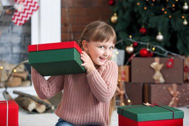 Evde Noel hediyeleri olan sevimli küçük bir kız.