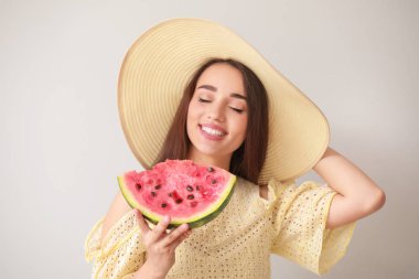 Hafif arka planda taze karpuz dilimi ile güzel genç kadın