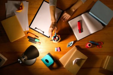 Akşam geç saatlerde masada çalışan kadın, üst görünümü