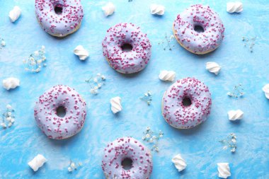 Tatlı lezzetli donuts, marshmallow ve renkli arka plan üzerinde çiçekler