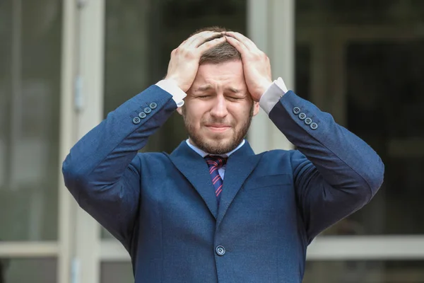 Businessman having panic attack outdoors