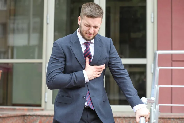 Businessman having panic attack outdoors