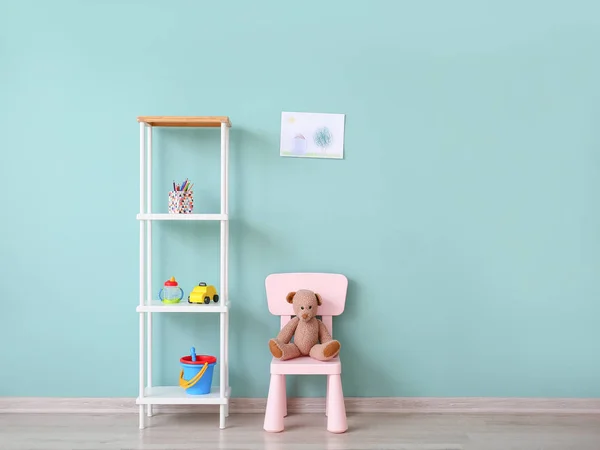 Stylish furniture with toys near color wall in children's room — Stock Photo, Image