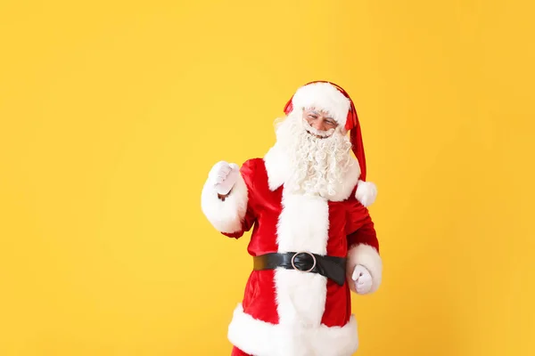 Portrait of Santa Claus listening to music on color background — Stock Photo, Image