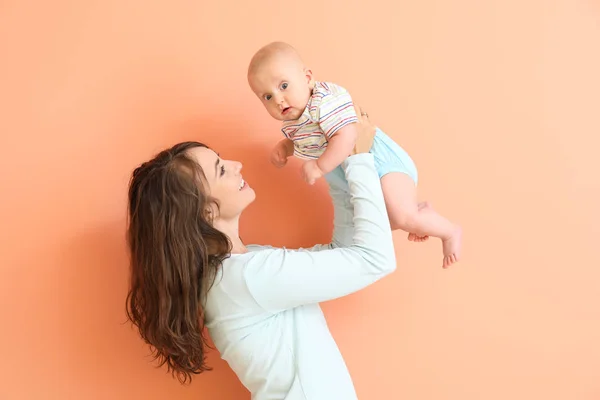 Happy mother and cute little baby on color background — Stock Photo, Image