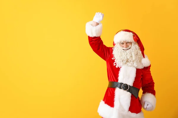 Porträt des Weihnachtsmannes, der Musik auf farbigem Hintergrund hört — Stockfoto