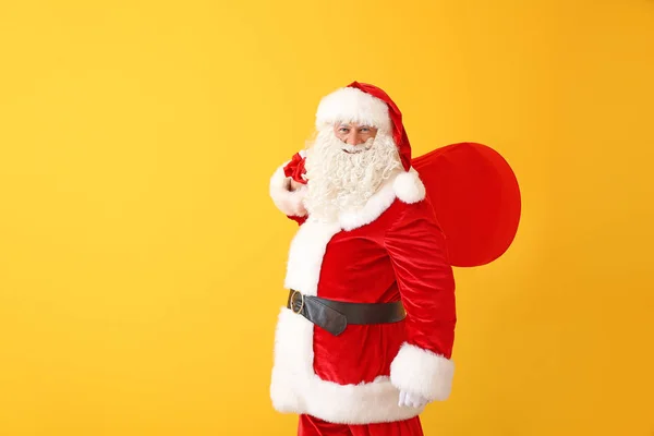 Portret van de kerstman met zak op kleur achtergrond — Stockfoto
