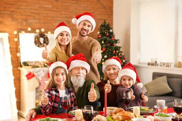 Lycklig familj som visar tummen upp gest under julbordet hemma — Stockfoto