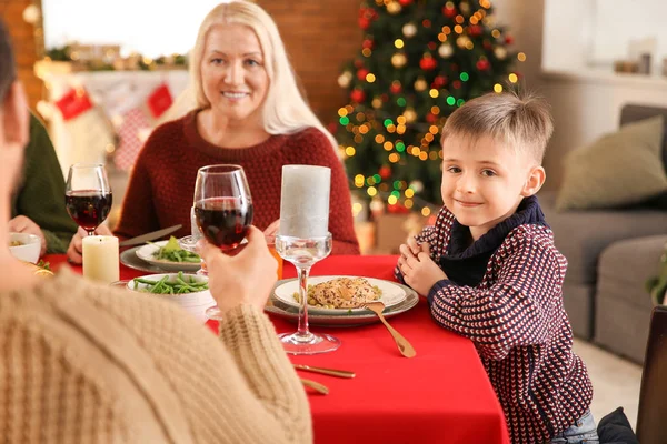 Lycklig liten pojke med sin familj med julbord hemma — Stockfoto