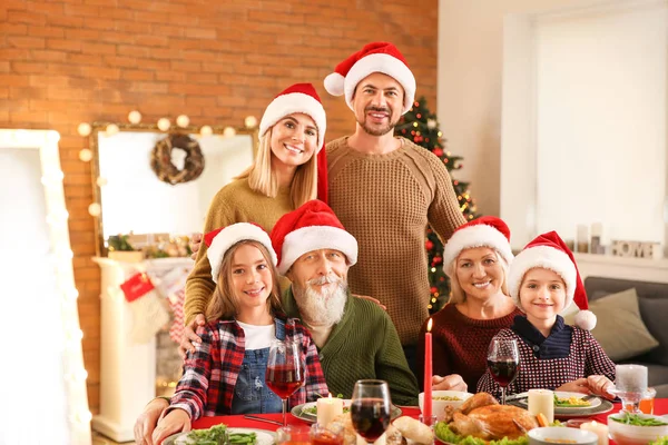 Lycklig familj i Santa Claus hattar firar jul hemma — Stockfoto