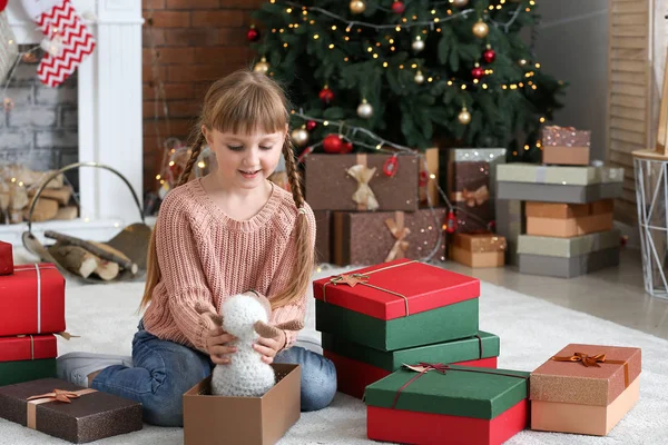 Nettes kleines Mädchen mit Weihnachtsgeschenken zu Hause — Stockfoto