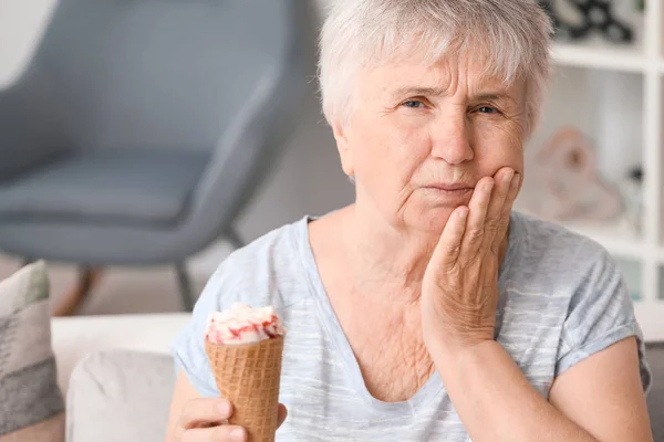 Старша жінка з чутливими зубами і холодним морозивом вдома — стокове фото