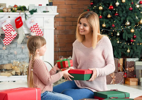 Cute little girl and her mother with Christmas gifts at home — Stock Photo, Image