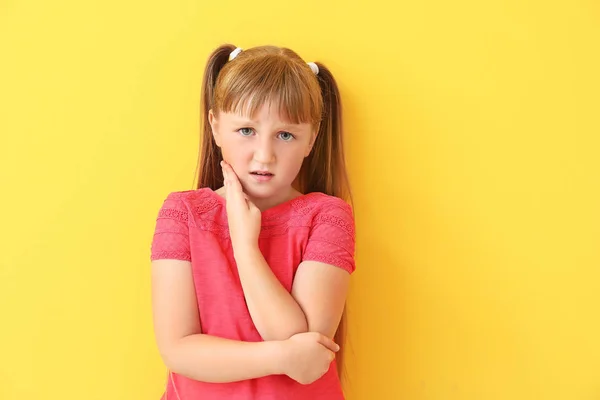 Bambina che soffre di mal di denti su sfondo di colore — Foto Stock