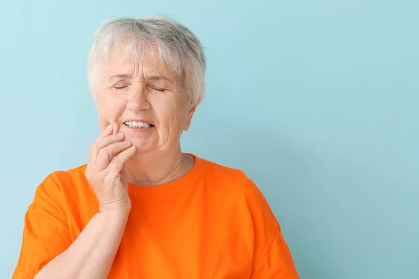 Senior nő szenved fogfájás ellen színes háttér — Stock Fotó