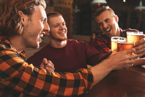 Vänner dricker färskt öl i pub — Stockfoto