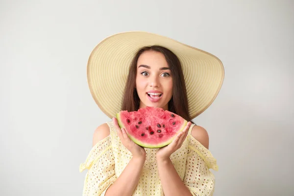 Beautiful young woman with slice of fresh watermelon on light background — Stock Photo, Image