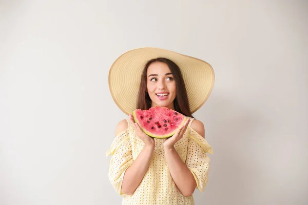 Schöne junge Frau mit Scheibe frischer Wassermelone auf hellem Hintergrund — Stockfoto